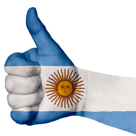 Hand with thumb up gesture in colored argentina national flag as symbol of excellence, achievement, good, - for tourism and touristic advertising, positive political, social management of countryの写真素材