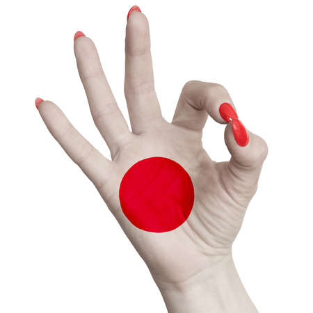 Japan national flag painted on female hand showing ok sign. Image on a white backgroundの写真素材