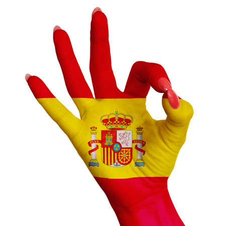 The national flag of Spain is painted on a female hand showing the sign OK. Image on a white backgroundの写真素材