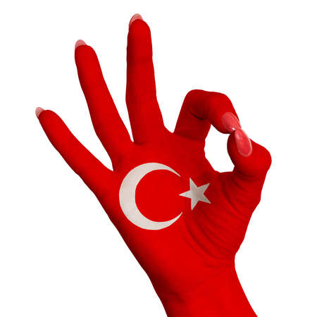 The national flag of Turkey is painted on a female hand showing the OK sign. Image on a white backgroundの写真素材