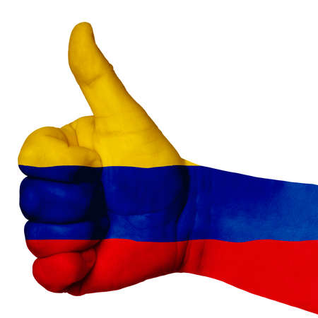 Hand with thumb up gesture in colored colombia national flag as symbol of excellence, achievement, good, - for tourism and touristic advertising, positive political, social management of countryの写真素材