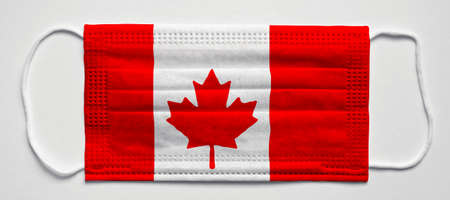 Canada flag. PANDEMIA. Medical mask, Medical protective mask on a white background.Healthcare and medical concept.の写真素材