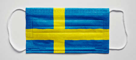 Sweden flag. PANDEMIA. Medical mask, Medical protective mask on a white background.Healthcare and medical concept.の写真素材
