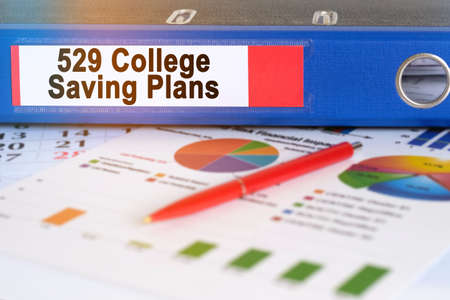 On the table are pie charts, a pen and a folder with the inscription - 529 College Saving Plans. Business and finance concept.の写真素材