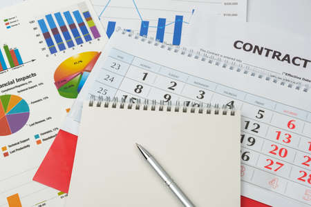 Business goal concept. Business accessory, graph charts, calendar, notebook and pen on the tableの写真素材