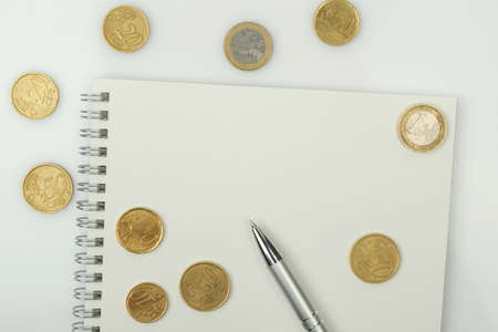 Coins, blank notepad and pen on a white background. Business and technology concept. copy spaceの写真素材