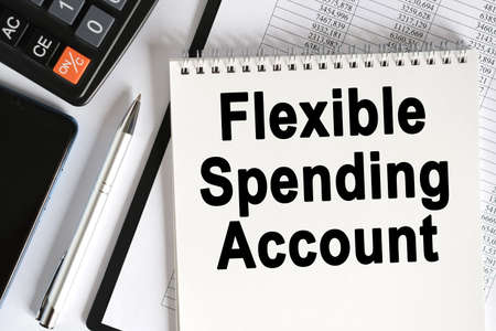 On the table lies a smartphone, a calculator and a notebook with the inscription- Flexible spending account. Business conceptの写真素材