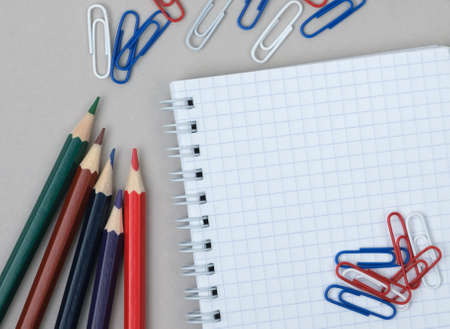 Workspace with paper clip, notebook and pencils on a white background. Business conceptの写真素材