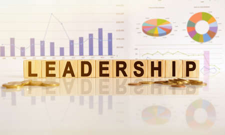 LEADERSHIP the word on wooden cubes, cubes stand on a reflective surface, in the background is a business diagram. Business and finance conceptの写真素材