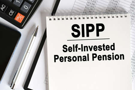 On the table lies a smartphone, a calculator and a notebook with the inscription- SIPP. Self Invested Personal Pension. Business conceptの写真素材
