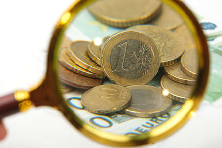 hand magnifier over euro banknote isolated on white background. Financial conceptの写真素材