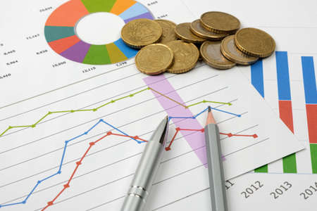 Business goal concept. Business accessory, graph charts and pencil and coins on the table.の写真素材