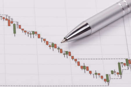 Technical chart of financial instruments on a table with a metal ballpoint pen. Forex analysis.の写真素材