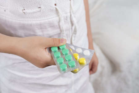 Sick teenage girl spills pills on her hand. Medical concept.の写真素材