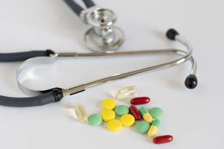Medical concept with colorful pills and stethoscope on white. Close-upの写真素材
