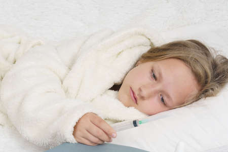 Sick teenage girl holding a medical syringe. Medical concept.の写真素材