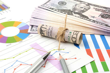 Business goal concept. Business accessory, graph charts and pencil and dollars on the table.の写真素材