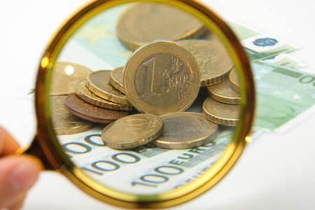 hand magnifier over euro banknote isolated on white background. Financial concept