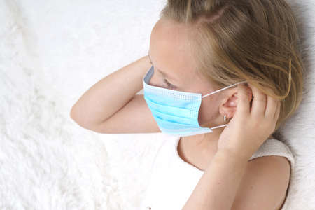A sick teenage girl takes pills and drinks them with water. Medical concept.の写真素材