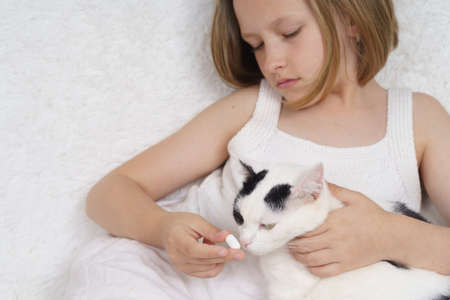 Sick teenage girl puts on a medical protective mask for a toy. Medical concept.の写真素材