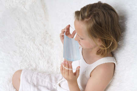 Sick teenage girl wears a medical protective mask. Medical concept.の写真素材