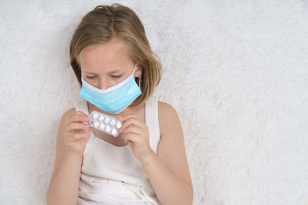 Sick teenage girl wears a medical protective mask. Medical concept.の写真素材