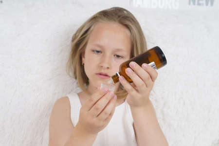 Sick teenage girl wears a medical protective mask. Medical concept.の写真素材
