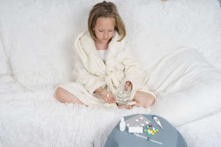 Sick teenage girl wears a medical protective mask. Medical concept.の写真素材