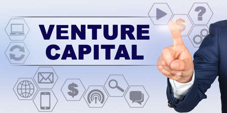 Business concept. Businessman touching virtual screen with his finger. Screen caption - VENTURE CAPITALの写真素材