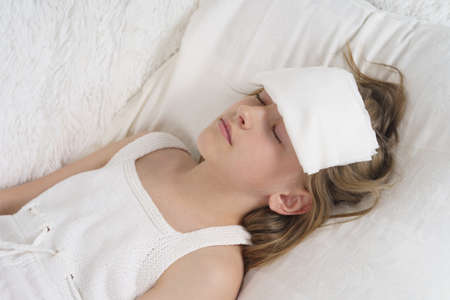 A sick teenage girl measures the temperature, next to her is a cat. Medical concept.の写真素材