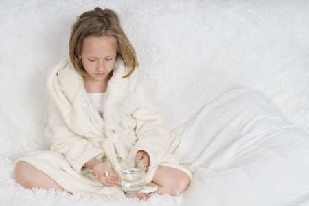 A sick teenage girl measures the temperature, next to her is a cat. Medical concept.の写真素材