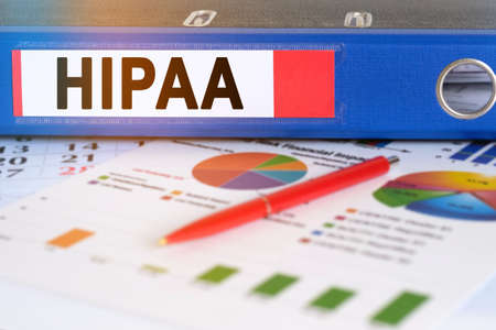 On the table are pie charts, a pen and a folder with the inscription - HIPAA. The Health Insurance Portability And Accountability Act of 1996. Business and finance concept.の写真素材