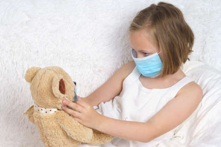 A sick teenage girl measures the temperature, next to her is a cat. Medical concept.の写真素材