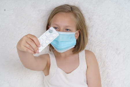 A sick teenage girl measures the temperature, next to her is a cat. Medical concept.の写真素材