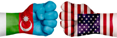 The concept of the struggle of peoples. Two hands are clenched into fists and are located opposite each other. Hands painted in the colors of the flags of the countries. Azerbaijan vs USAの写真素材