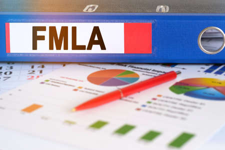 On the table are pie charts, a pen and a folder with the inscription - FMLA. Family and Medical Leave Act. Business and finance concept.の写真素材