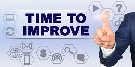 Business concept. Businessman touching virtual screen with his finger. Screen caption - TIME TO IMPROVEの写真素材