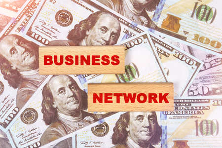 Business concept. Against the background of dollar bills, the text is written on wooden blocks - business networkの写真素材