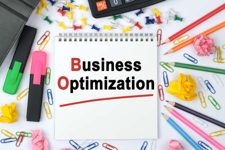 Business concept. On the table is a calculator, diary, markers, pencils and a notebook with the inscription - Business Optimizationの写真素材
