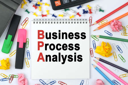 Business concept. On the table is a calculator, diary, markers, pencils and a notebook with the inscription - Business Process Analysisの写真素材