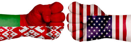 The concept of the struggle of peoples. Two hands are clenched into fists and are located opposite each other. Hands painted in the colors of the flags of the countries. Belarus vs USAの写真素材