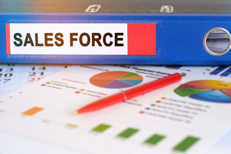 On the table are pie charts, a pen and a folder with the inscription - SALES FORCE. Business and finance concept.の写真素材