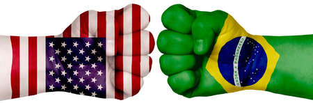 The concept of the struggle of peoples. Two hands are clenched into fists and are located opposite each other. Hands painted in the colors of the flags of the countries. Brazil vs USAの写真素材
