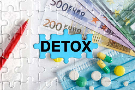 Double exposure. Puzzles with the image of pills, medical mask, pens and euro with the inscription -DETOX. The concept of medicine.の写真素材