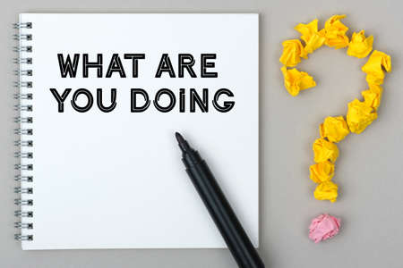 Hand with marker writing: What Are you Doing. Notepad and question mark.の写真素材