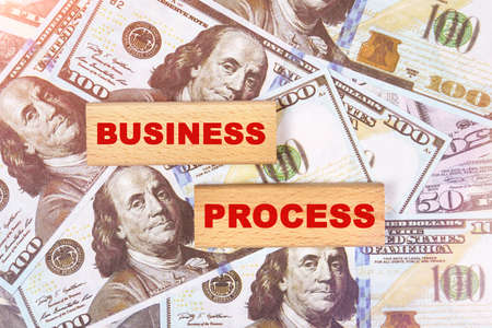 Business concept. Against the background of dollar bills, the text is written on wooden blocks - business processの写真素材