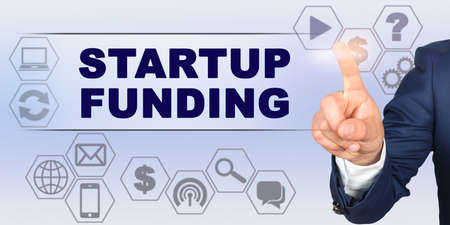 Business concept. Businessman touching virtual screen with his finger. Screen caption - STARTUP FUNDINGの写真素材