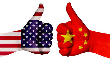 The concept of strengthening the relationship of nations. Two hands are painted with flags of different countries, with a thumb raised up. China and the USAの写真素材
