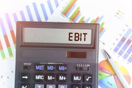 The concept of business and finance. On the table are financial charts and a calculator, on the electronic board of which is written the text - EBITの写真素材