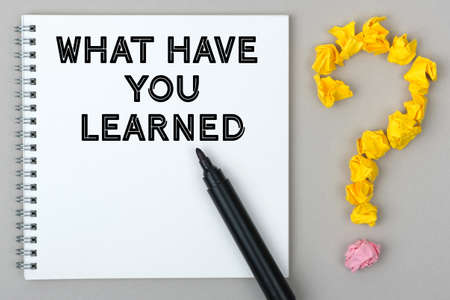 Hand with marker writing: What Have You Learned. Notepad and question mark.の写真素材